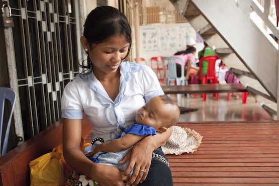 柬埔寨母亲微笑着俯视着怀中的婴儿